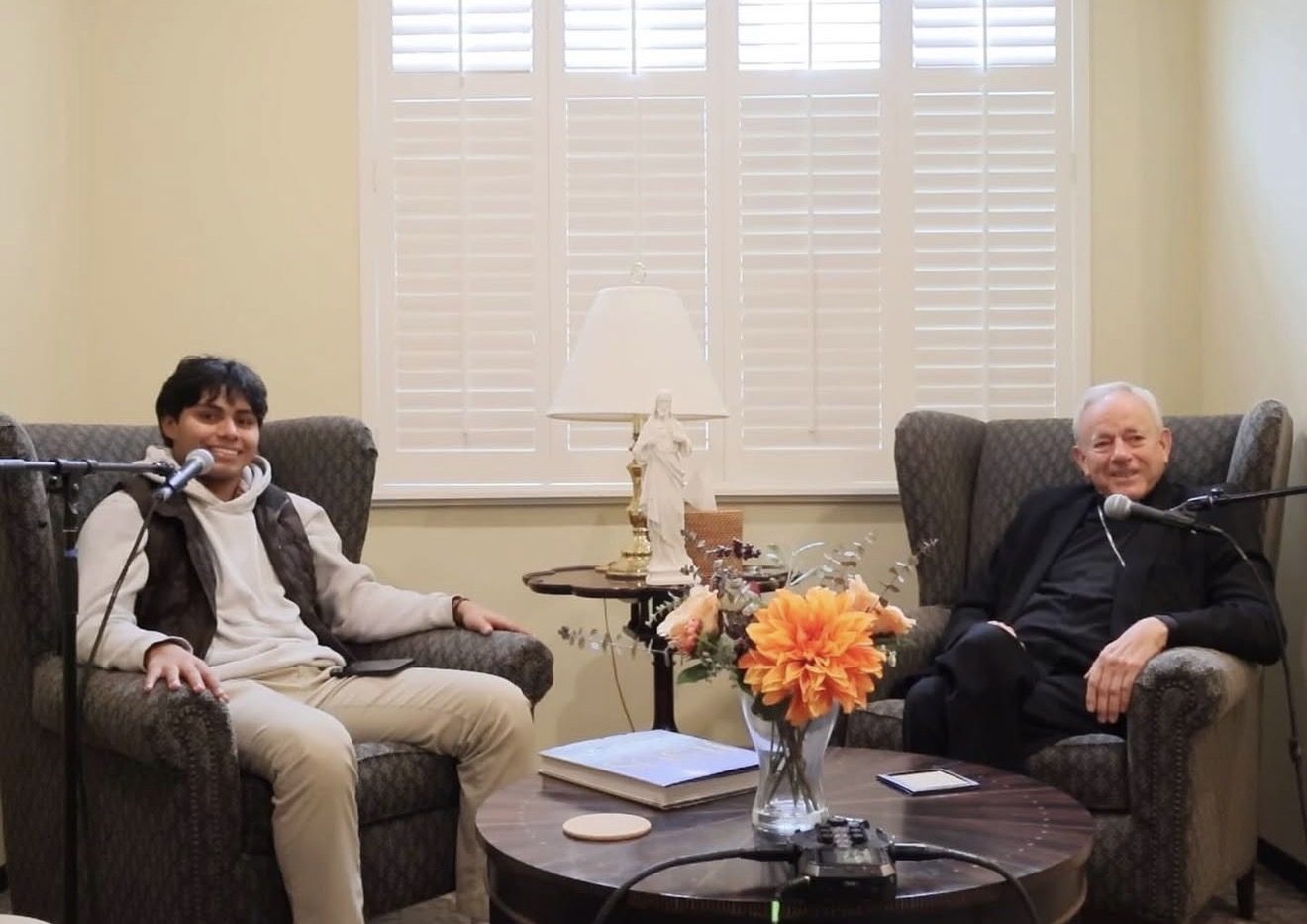 Manny Campos recording a podcast episode with a bishop